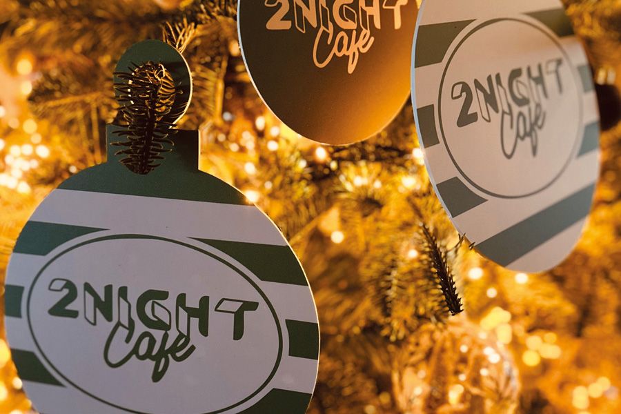 Een kerstkaartje uitgesneden als kerstbal, om zo aan de kerstboom te hangen.
